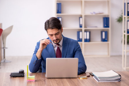 Young male employee sitting at workplaceの写真素材