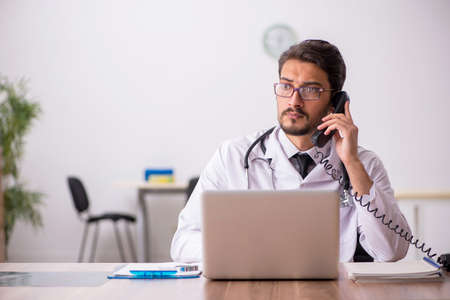 Young male doctor in telemedicine conceptの写真素材