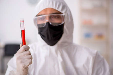 Young male chemist in drugs synthesis concept