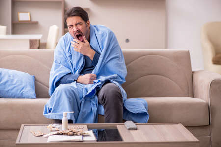 Young man feeling bad at homeの写真素材