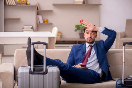 Young businessman preparing for trip at homeの写真素材