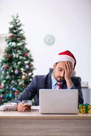 Young male employee celebrating Christmas at workplaceの写真素材