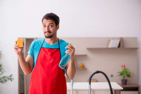 Young male contractor cleaning the houseの写真素材