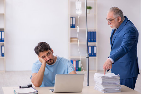Young male employee feeling bad at workplaceの写真素材