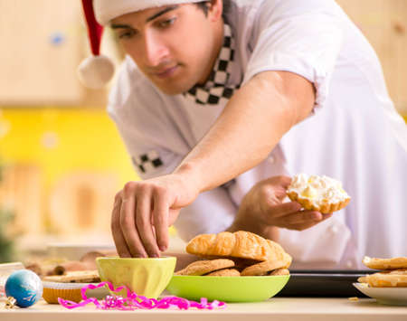 Young chef husband working in kitchen at Christmas eveの写真素材