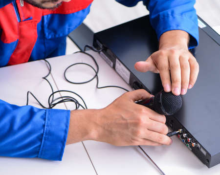 Man repairman repairing dvd player at service centerの写真素材
