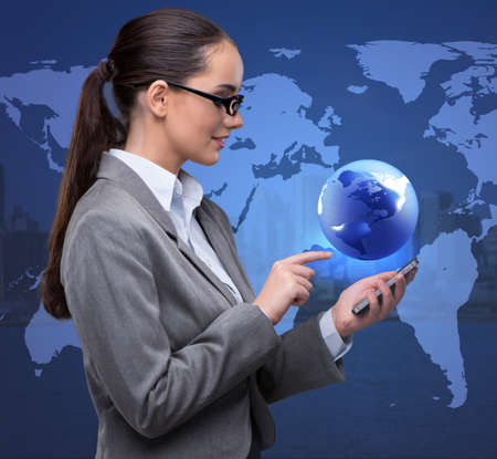 Businesswoman with phone in global business conceptの写真素材