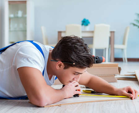 Repairman laying laminate flooring at homeの写真素材
