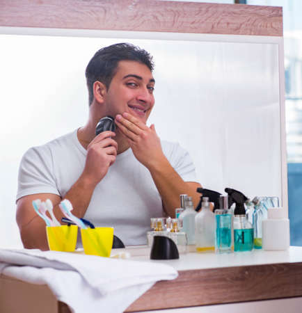 Young handsome man shaving in the morningの写真素材