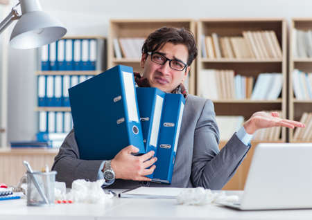 Sick businessman suffering from illness in the officeの写真素材