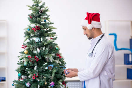 Young male doctor celebrating Christmas at the hospitalの写真素材