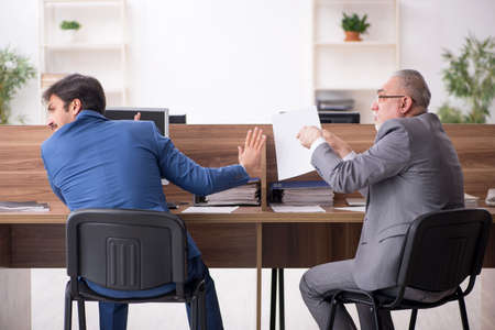 Two male employees working in the officeの写真素材