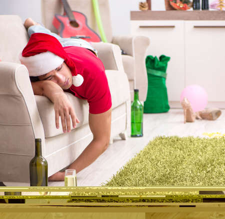Young man drunk at home after christmas partyの写真素材