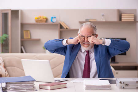 Old male employee working from home during pandemicの写真素材
