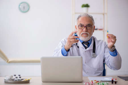 Old male doctor pharmacist working at the labの写真素材