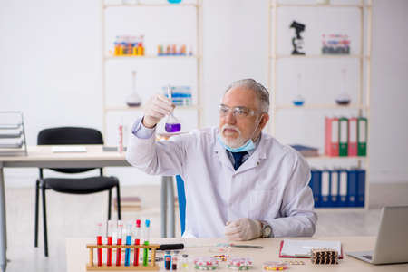 Old male chemist in drug synthesis conceptの写真素材
