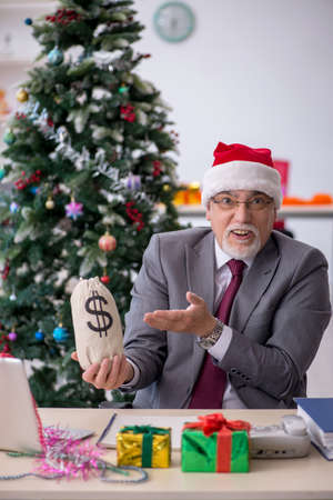 Aged male employee celebrating Christmas at workplaceの写真素材