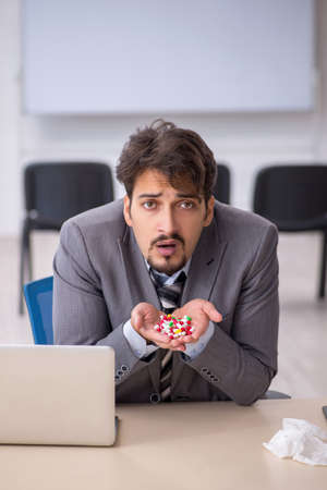 Young businessman employee suffering at workplaceの写真素材