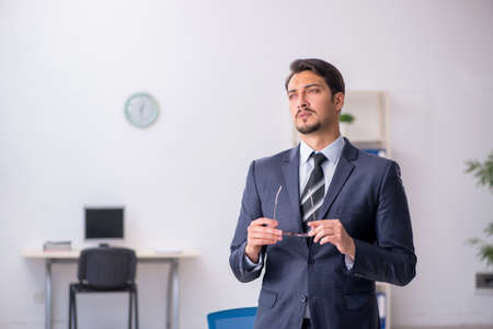Young male employee sitting at workplaceの写真素材