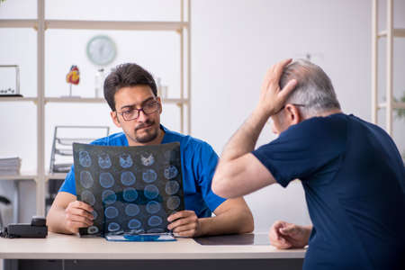 Old man visiting young male doctor radiologistの写真素材