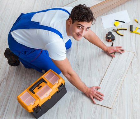 Repairman laying laminate flooring at homeの写真素材