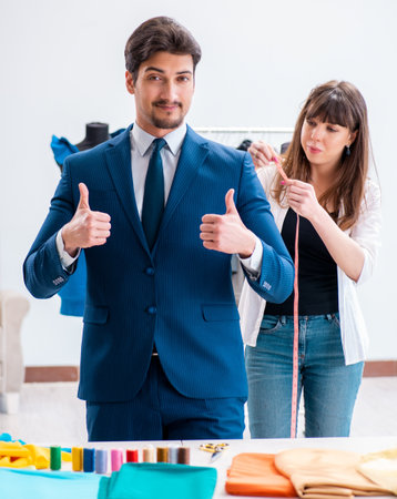Professional tailor taking measurements for formal suitの写真素材