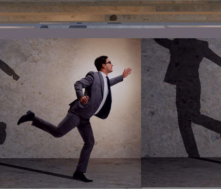 Businessman and his shadow in business conceptの写真素材