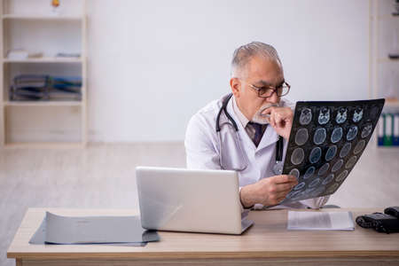 Old male doctor radiologist working at the hospital