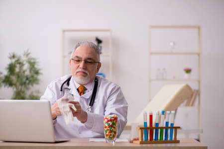 Old male doctor pharmacist working in the clinicの写真素材