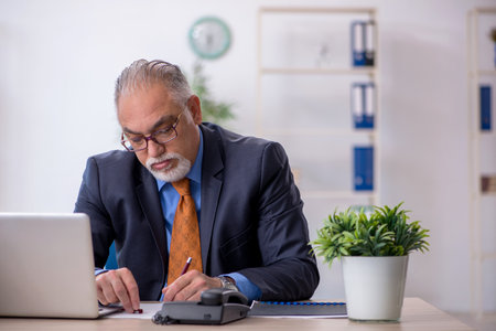 Old boss working in the officeの写真素材