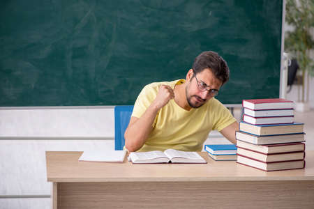 Young male student preparing for exams in the classroomの写真素材