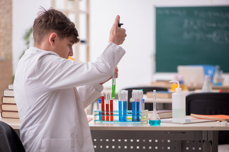 Schoolboy studying chemistry in the classroomの写真素材