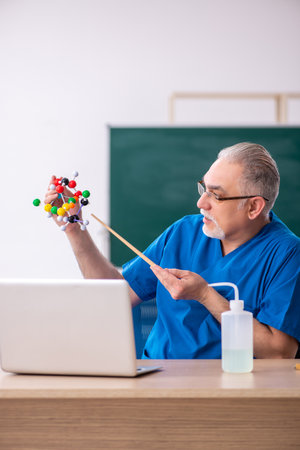 Old male teacher chemist in the classroomの写真素材