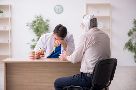 Old male patient visiting young male doctor dentistの写真素材