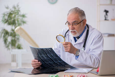 Old male doctor radiologist working in the clinicの写真素材