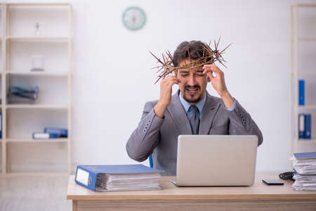 Young male employee wearing prickly wreath on headの写真素材