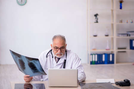 Old male doctor radiologist working at the hospital