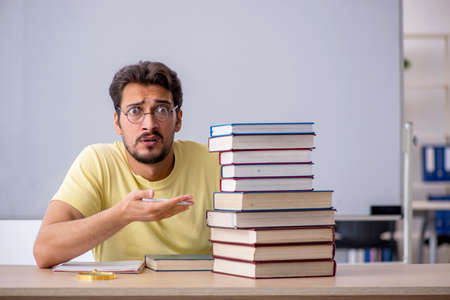 Young male student preparing for exams in the classroom