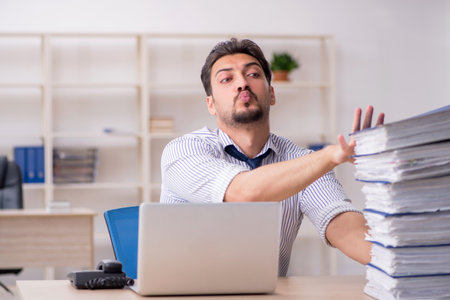Young male employee and too much work in the office