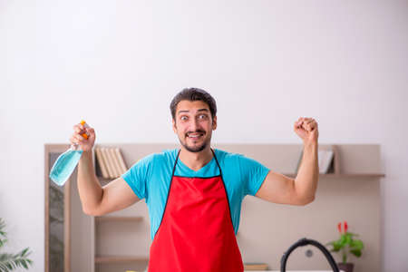 Young male contractor cleaning the houseの写真素材