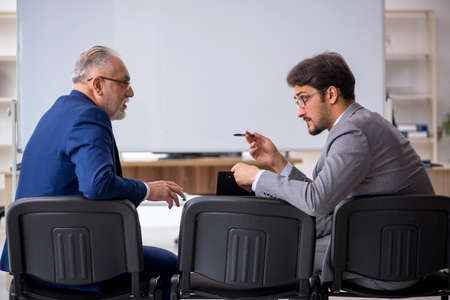 Two male colleagues in business presentation conceptの写真素材