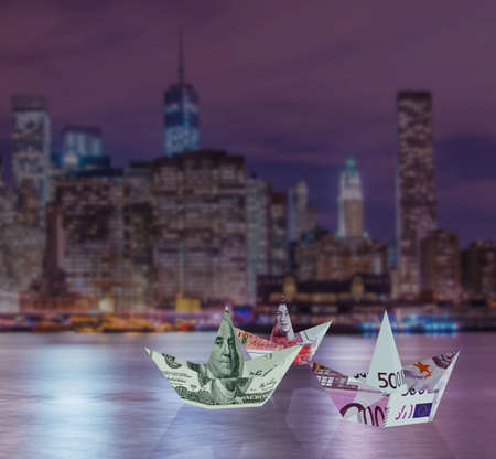 Euro and dollar boats against cityscapeの写真素材