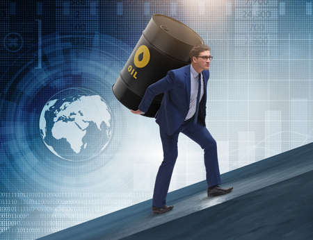 Businessman under the burden of oil barrelの写真素材