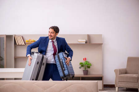 Young businessman preparing for trip at homeの写真素材
