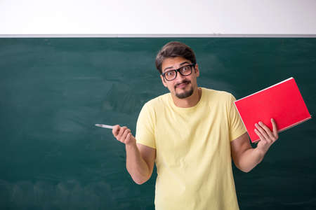 Young male student in front of blackboardの写真素材