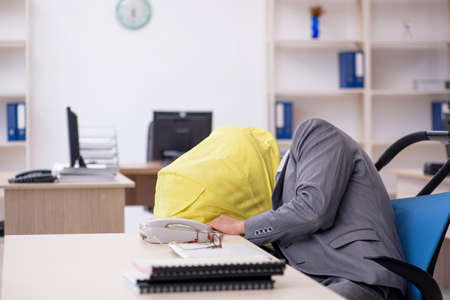 Young male employee looking after new born at workplaceの写真素材