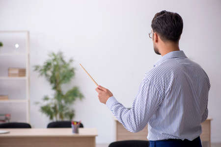 Young male teacher in the classroomの写真素材