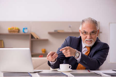 Old male employee working from home during pandemicの写真素材