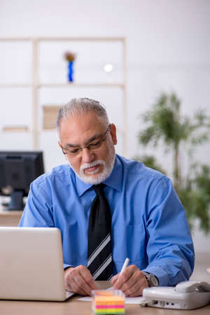 Old male employee working in the officeの写真素材