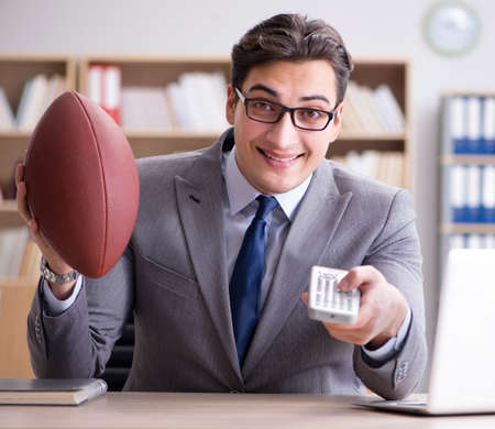 Businessman with american football in officeの写真素材